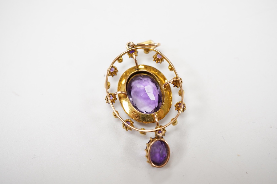 An Edwardian amethyst and seed pearl pendant, early 20th century, set with an oval amethyst, within a border of split seed pearls, to an outer frame set with circular-cut amethysts and seed pearls, suspending an oval ame
